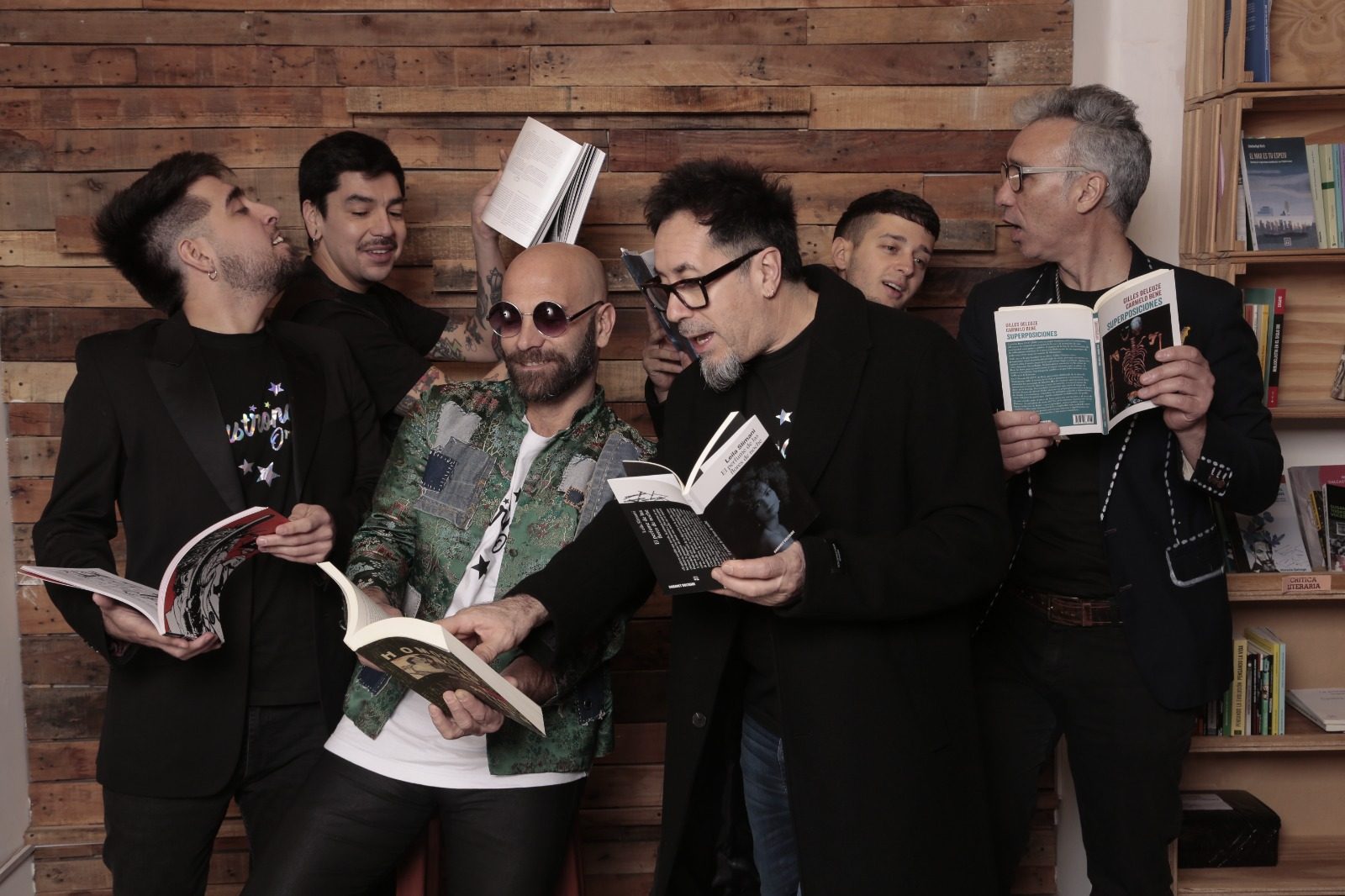 Los músicos leyendo libros en una librería, en pose divertida